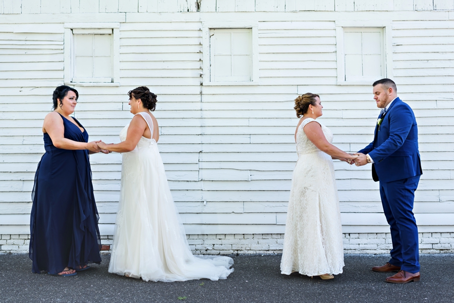 Two brides are helped by their siblings before seeing each other for the first time on their wedding day.